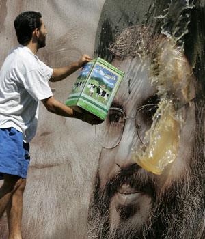 A Lebanese man washes a picture of Hezbollah leader Hassan Nasrallah in the southern suburb's of Beirut, a stronghold of the Lebanese Shiite militant group, 29 July 2006 (AFP)