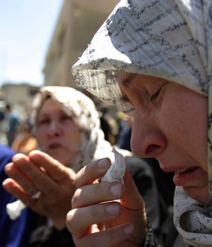 Lebanese women refugees who escaped from their houses cry as they wait at the border village of Rmeish in south Lebanon, where about 30,000 refugees have been cut off, 28 July 2006 (AFP)