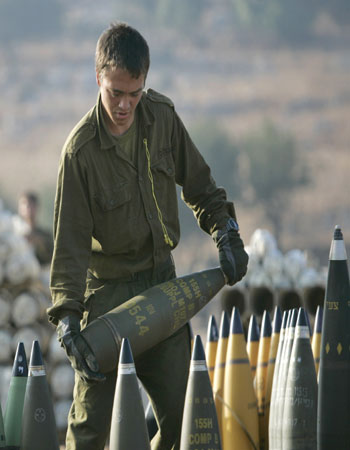 An Israeli soldier prepares artillery shells at a position in northern Israel (AP)