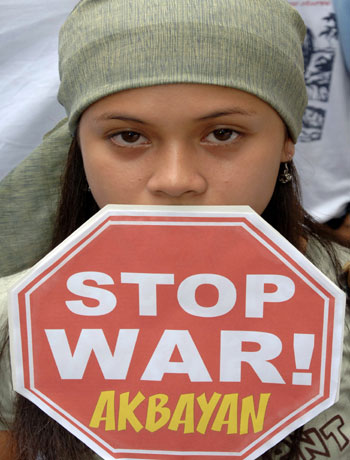 A Filipina Muslim protester holds a placard during an anti-war rally outside the Israel embassy in Manila (R)
