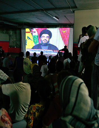 A group of displaced Lebanese watch a taped television speech of Hezbollah leader Hassan Nasrallah on a large screen in a shelter in Beirut (AP)
