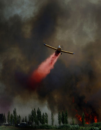 An Israeli firefighter plane works on fires caused by Katyusha-style rockets fired by Hezbollah (AFP)