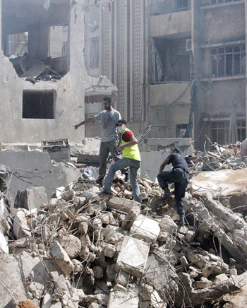 Lebanese rescue workers inspect the rubble of a destroyed building in the Shiyeh district of Beirut (EPA)