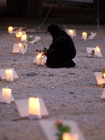 A Lebanese woman lights candles in Beirut's central district to protest against the rising number of civilian victims (EPA)