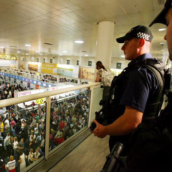 Armed policemen keep watch over people waiting at Gatwick Airport, London's second largest airport (EPA)
