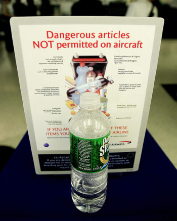 A bottle of water sits in front of a sign informing passengers what items they are not allowed to bring on flights at JFK airport NY (EPA)