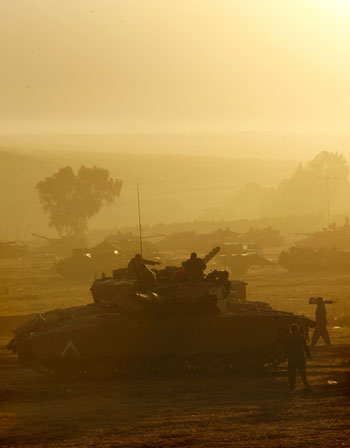 Israeli armored vehicles are silhouetted at dawn near northern town of Kiryat Shmona on Israel-Lebanon border (R)