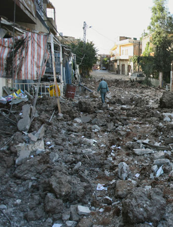 A Lebanese man walks through the rubble of one of three buildings attacked during an Israeli air raid at the village of Ali Alnahri (AP)