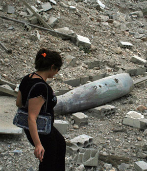 A Lebanese woman and her family (unseen) walks past an unexploded Israeli missile in the border town of Khiam, located just seven kilometres (four miles) from the Israeli border, 20 August 2006 (AFP)