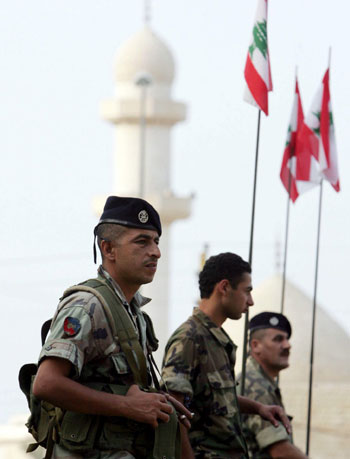 Lebanese soldiers stand guard atop armored personnel carriers (EPA)