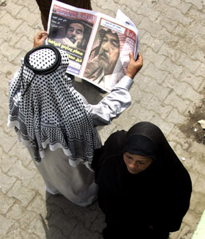 An Iraqi reads a newspaper in Baghdad 22 August 2006 as ousted president Saddam Hussein's trial on genocide charges resumed following a brief closed-door meeting between judges and lawyers to deal with procedural matters (AFP)