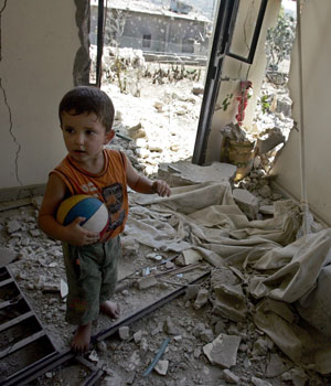 A Lebanese boy plays with a ball inside a destroyed house in Aita Chaab, southern Lebanon, August 23, 2006 (EPA)
