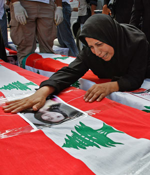 A Lebanese woman grieves over the coffin of a family member removed from a mass grave and draped with the Lebanese national flag in the southern port city of Tyre, Lebanon, August 24, 2006 (AP)