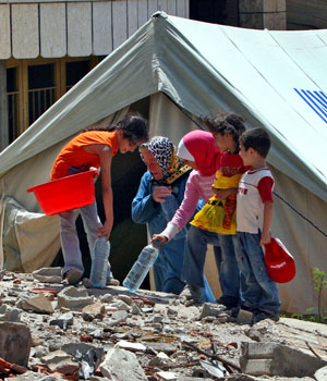 Children assist their grand mother in front of their tent in the Debbine village, south Lebanon, Aug. 25, 2006 (AP)