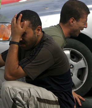 Relatives of killed Palestinian Yasser al-Gharabli cry outside the morgue of the al-Shifa hospital where his body was transported in Gaza City, 30 August 2006 (AFP)