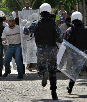 Palestinian riot police run towards unemployed workers trying to break into the Palestinian parliament compound during a demonstration to demand jobs in Gaza City, Aug. 29, 2006 (AP)