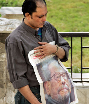 A mourner holds a newspaper showing a photograph of Egyptian novelist and Nobel laureate Naguib Mahfouz, who died Aug. 30, 2006, at a funeral prayer ceremony held at the al-Hussein Mosque in Cairo, Egypt, Aug. 31, 2006.