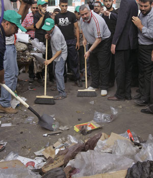 Palestinian Prime Minister Ismail Haniyeh sweeps the floor as part of a cleaning campaign with Hamas volunteers in Gaza City, Sept. 1, 2006 (AP)