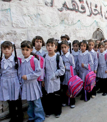 Palestinian girls stand by their school after their teachers went on strike over unpaid wages (EPA).