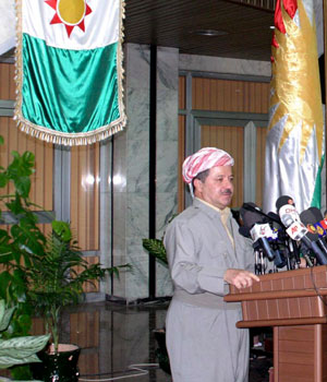 Iraq's Kurdistan president Massoud Barzani is flanked by an Iraqi flag from the 1960's (L) and the present Kurdistan flag (R) as he speaks during a conference in Arbil, about 350 km (220 miles) north of Baghdad, September 3, 2006 (REUTERS)