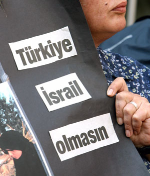 A protester holds a poster that reads "Don't let Turkey become Israel" during a protest against Turkey's decision to send troops to Lebanon, 5 September 2006 (REUTERS)