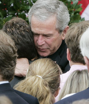 President Bush hugs an unidentified woman as he greets friends and family members of victims at the Pentagon shortly after he laid a wreath marking the fifth anniversary of the terrorist attacks, Sept. 11, 2006 in Washington (AP)