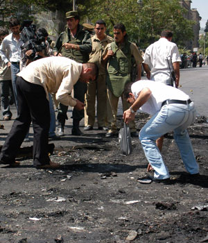 Syrian security officers inspect the area near the U.S. embassy compound in Damascus, which was the target of an attack September 12, 2006 (REUTERS)