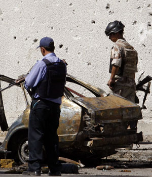 An Iraqi policeman and a soldier inspect the scene of a bomb attack in Baghdad, September 16, 2006 (REUTERS)