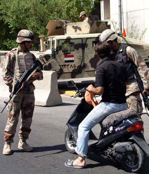 Iraqi troops stop a motorist at a checkpoint in Baghdad 15 September 2006 (AFP)
