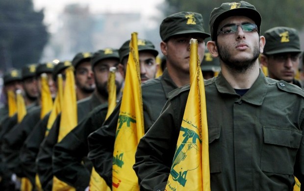In this November 12, 2010 file photo, Hezbollah fighters hold their party flags, as they parade during the opening of new cemetery for colleagues who died in fighting against Israel, in a southern suburb of Beirut, Lebanon.AP Photo/Hussein Malla