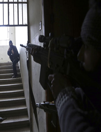 A Free Syrian Army fighter gestures as he checks Syrian Army positions during clashes in the Haresta neighbourhood of Damascus February 1, 2013. (Reuters)