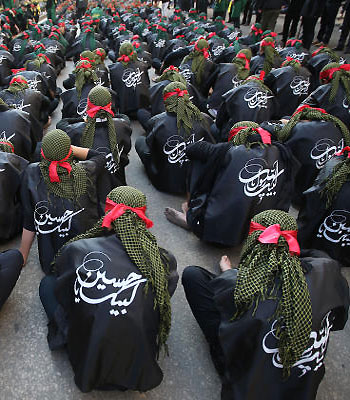 Shiite supporters of Hezbollah, sit on the ground as they listen to the death story of Imam Hussein, during a march in southern Beirut. (AP)