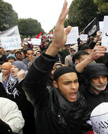 Supporters of the Ennahda ruling party shout slogans and wave flags during a demonstration in Tunis February 9, 2013.(R)