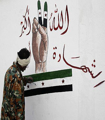 A member of the Free Syrian Army paints on Al-Moshat school wall in Aleppo. (R)