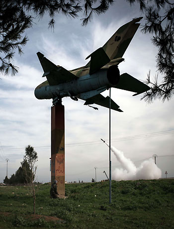 Syrian rebels fire a rocket towards regime forces stationed at Kwiriss airport in Al-Bab, 30 kilometres from the northeastern Syrian city of Aleppo, on February 14, 2013. (AFP)