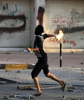 A Bahraini anti-government protester throws a petrol bomb toward riot police firing tear gas during clashes in Daih, Bahrain. (AP)