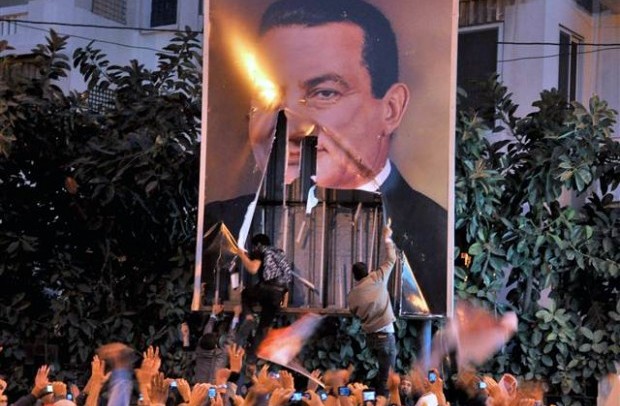 Egyptian demonstrators tear a portrait of President Hosni Mubarak during a protest against his rule in the northern port city of Alexandria on January 27, 2011. (AFP)