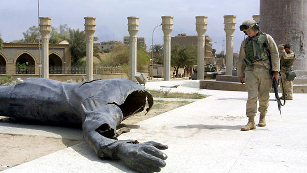 An April 10, 2003 photo shows US Marines walking past a dismounted statue of Saddam Hussein on Baghdad’s Fardous Square. (AFP PHOTO)