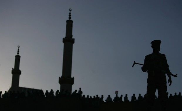 A police officer is silhouetted as he stands guard on a bridge overlooking the site of a parade commemorating the second anniversary of the uprising against Yemen's former president Ali Abdullah Saleh in Sanaa February 11, 2013. (REUTERS/Khaled Abdullah)