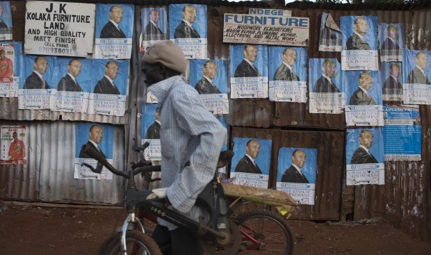 A cyclist moves past campaign posters of Kenya's presidential candidate Peter Kenneth at the Kangemi slum in Kenya's capital Nairobi February 28, 2013. (REUTERS/Siegfried Modola)