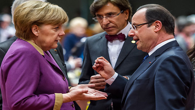 German Chancellor Angela Merkel, second left, speaks with French President Francois Hollande, right, during a round table meeting at an EU summit in Brussels on Friday, March 15, 2013. (AP Photo/Geert Vanden Wijngaert))