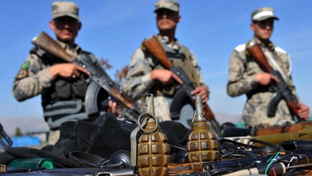 Afghan border police stand guard near seized weapons as they are displayed to the media at a police headquarters in Jalalabad on March 2, 2013. Seven Taliban insurgents have been arrested with their weapons by Afghan border police during an operation in Ghani khel District of Nangarhar province. (AFP PHOTO/ Noorullah Shirzada)