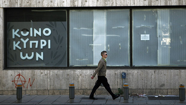A man passes an empty closed branch of Bank of Cyprus in central capital Nicosia, Cyprus, Sunday, March 24, 2013. (AP Photo)