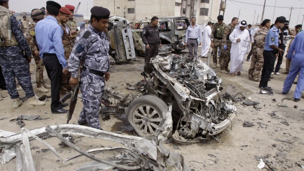 Iraqi security forces inspect the site of a car bomb attack in Basra, Iraq, Sunday, March 17, 2013. Iraqi authorities say two car bombs have killed several people and wounded scores of others in the country's south. (AP Photo/Nabil al-Jurani)