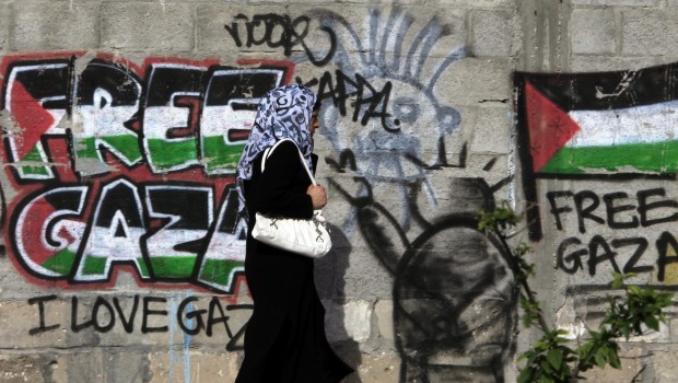 A Palestinian woman walks past a mural with text 'Free Gaza' in Gaza City, March 7, 2013. The two largest Palestinian groups have been at loggerheads for years despite mediation attempts by Egypt and other Arab countries. (EPA)