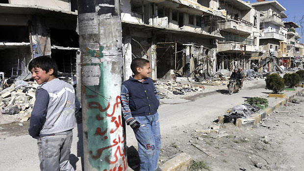 Syrian boys, stand in a destroyed street which was damaged by the shelling of the Syrian forces, at Maarat al-Nuaman town, in Idlib province, Syria. (AP)
