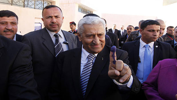 Jordanian Prime Minister Abdullah Ensour, gestures with his finger, showing the press the voting ink on his finger after he casts his vote at a polling station during the first hours of the Jordanian Parliamentary elections, in Al-Salt, Jordan, Wednesday Jan. 23, 2013. (AP)