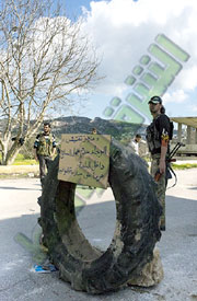 Checkpoint at the Kurdish village of Al Najiya. The sign reads 'Please do not bring weapons into the village. The reason is to protect civilians.' (AAA)