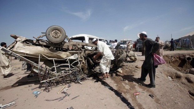 Security officials collect evidence from a damaged vehicle at the site of a bomb attack after a bomb blast in Jalozai camp iin Nowshera district, northwestern Pakistan March 21, 2013. (REUTERS)