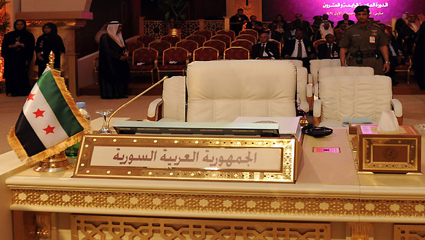 A pre-Baath Syrian flag, currently used by the Syrian opposition, is seen in front of the seat of the Syrian delegation at the opening of the Arab League summit in Doha, Qatar, 26 March 2013. (EPA)